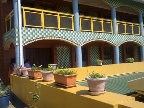 Residential quarters at the ashram, with yellow railings and a planted courtyard