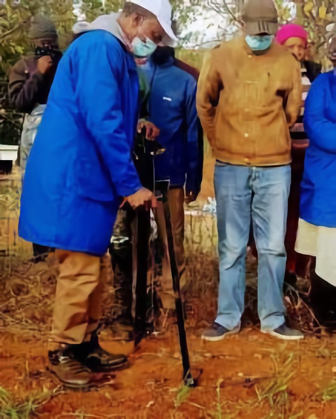 Participants planting vetiver in a prepared garden area