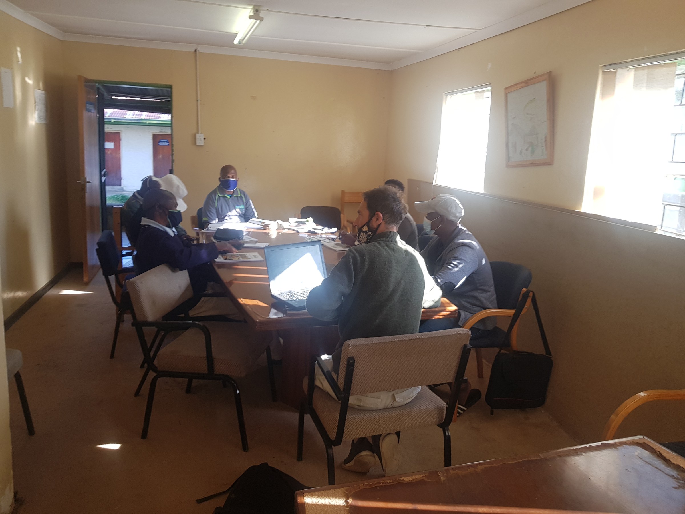 Rory Clark in a working session around a table with Lesotho government officials