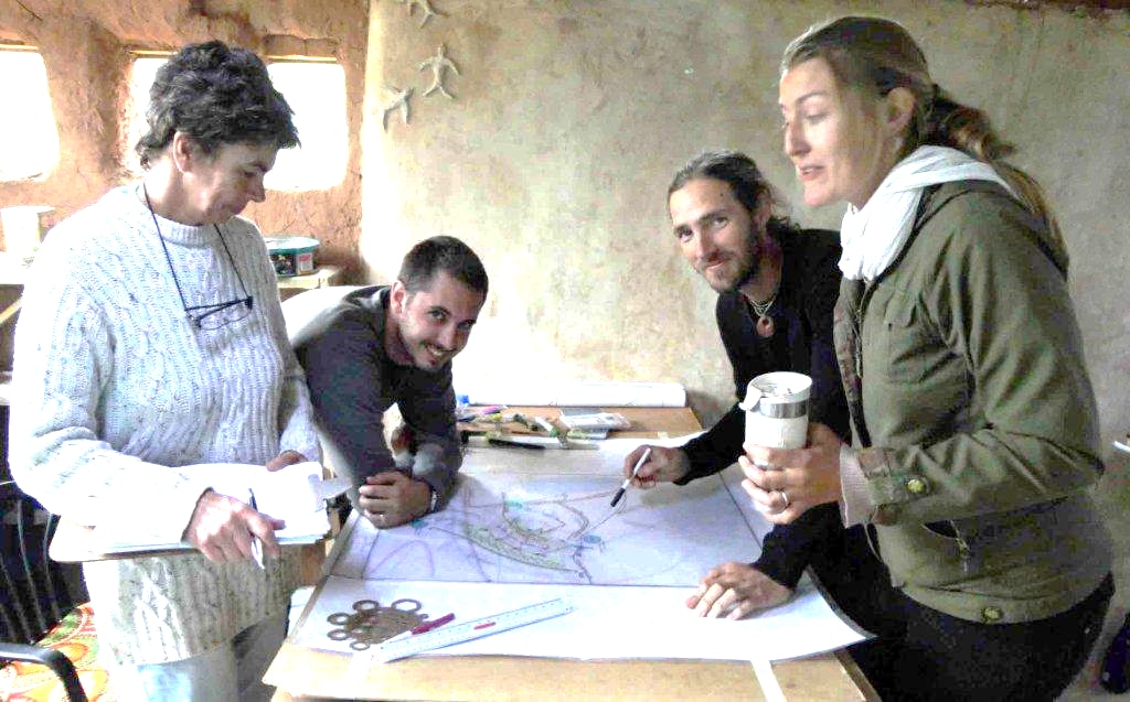 Rory Clark and fellow Permaculture Design Course participants working around a hand-drawn site plan